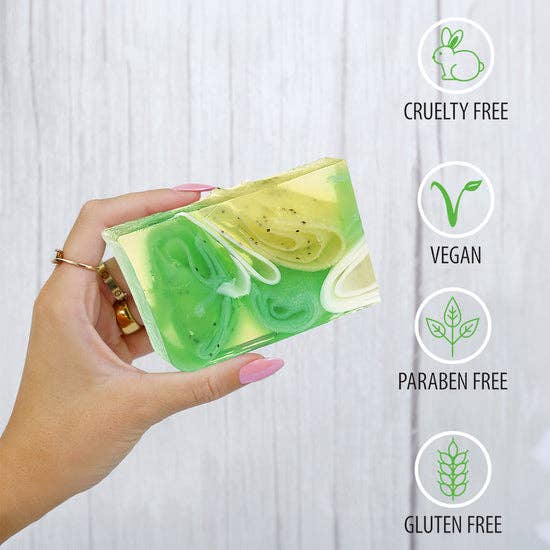 Hand holding a green and white swirled soap bar with icons indicating cruelty-free, vegan, paraben-free, and gluten-free benefits.