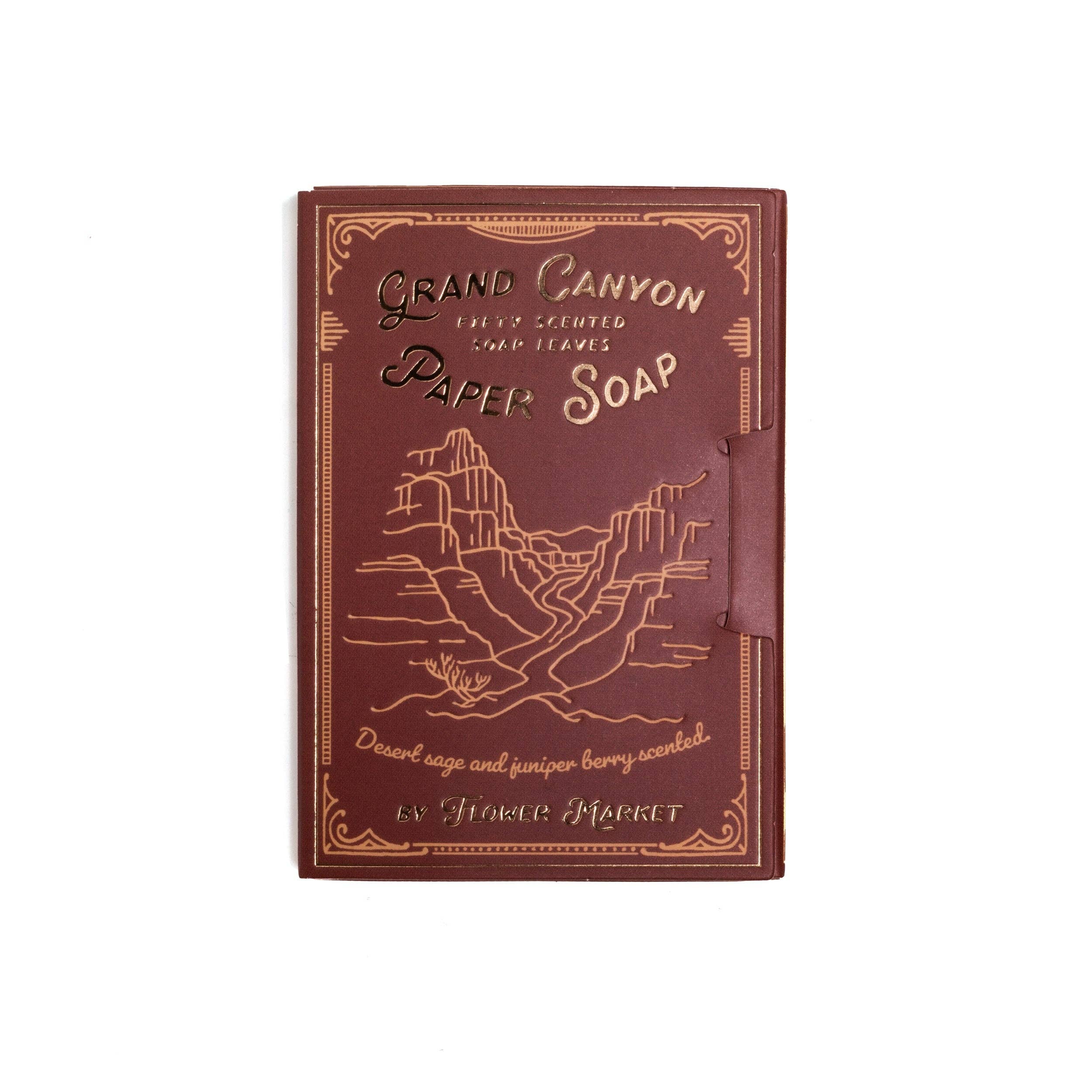 Close-up of a maroon box of Grand Canyon Paper Soap with gold embossed text and a mountain illustration, 50 dissolvable sheets for travel