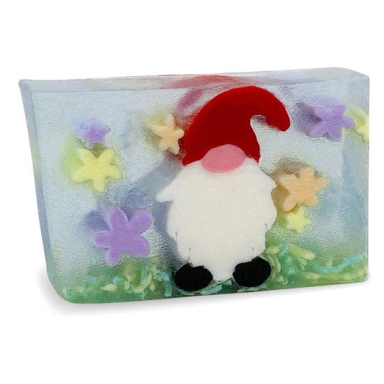 Decorative garden gnome-shaped soap with a red hat, white body, black feet, surrounded by colorful foam flowers, transparent packaging